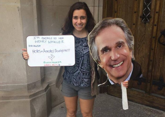 Cornell University student holding a giant cut-out of actor Henry Winkler's face
