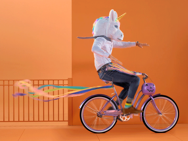 gif of a person wearing a unicorn mask and riding a bicycle