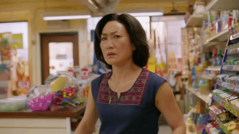 gif of a women grabbing a mop defensively in a grocery store