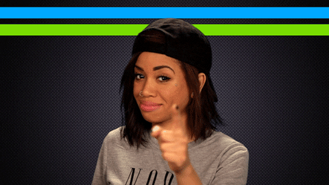 gif of a woman looking at the camera and pointing to her head, thinking