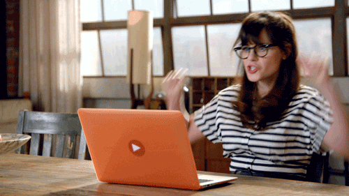 New Girl lead character reading laptop and doing a celebratory dance