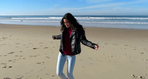 gif of a person dancing happily on the beach